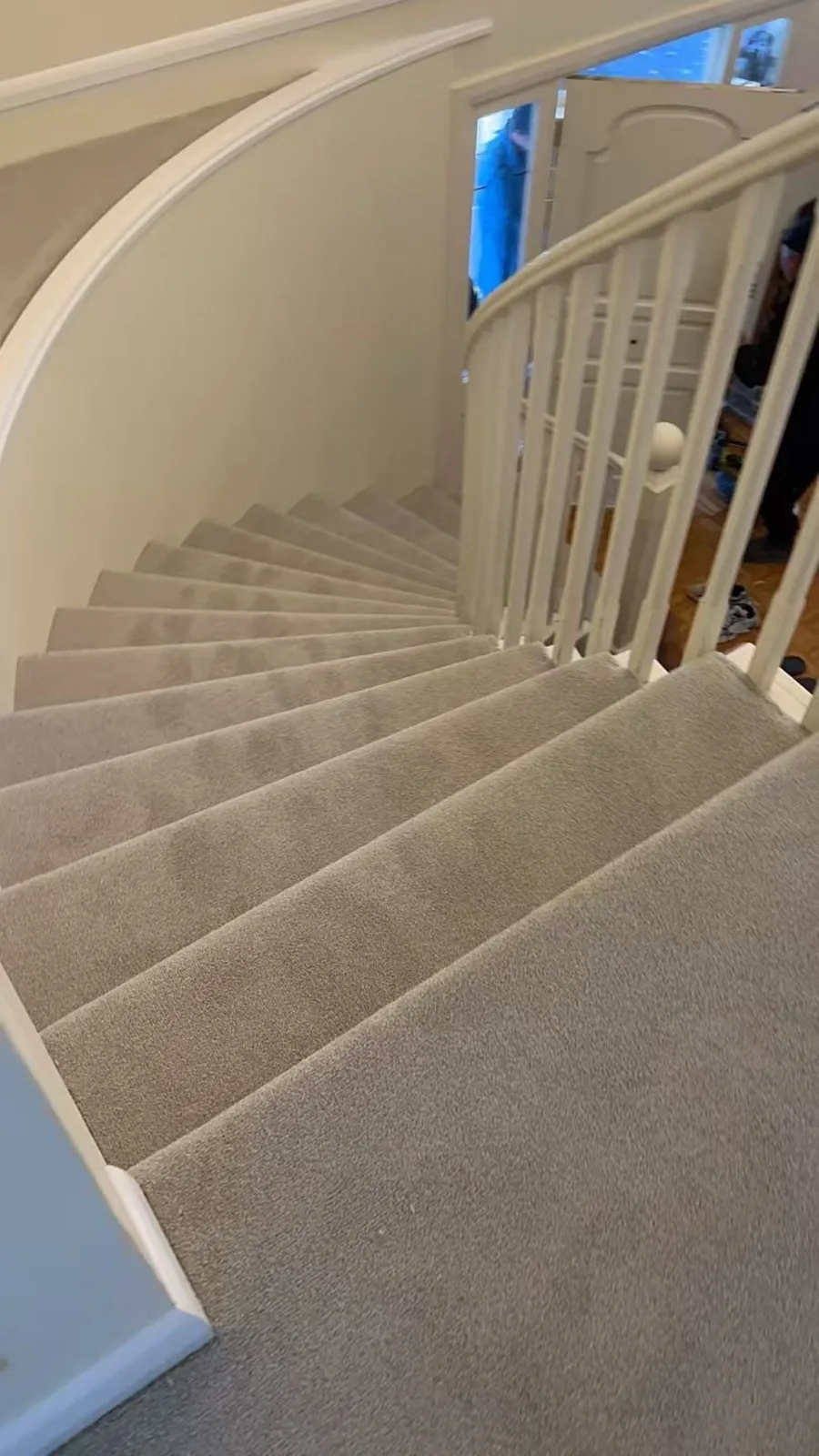 New light-grey carpet installed on a curved staircase