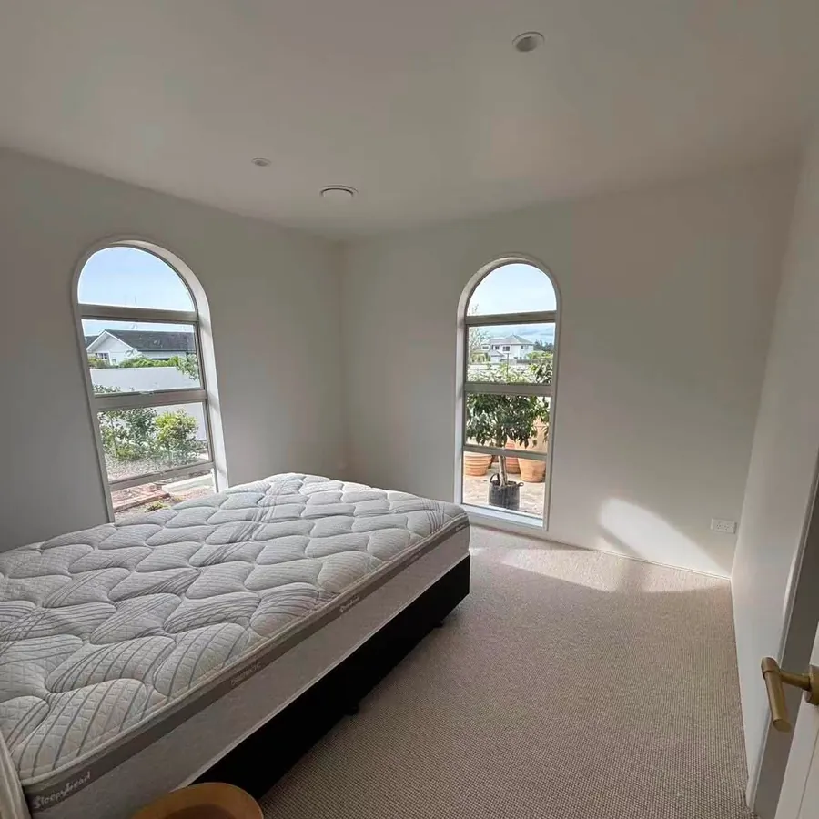 Bedroom with new carpet and arched windows